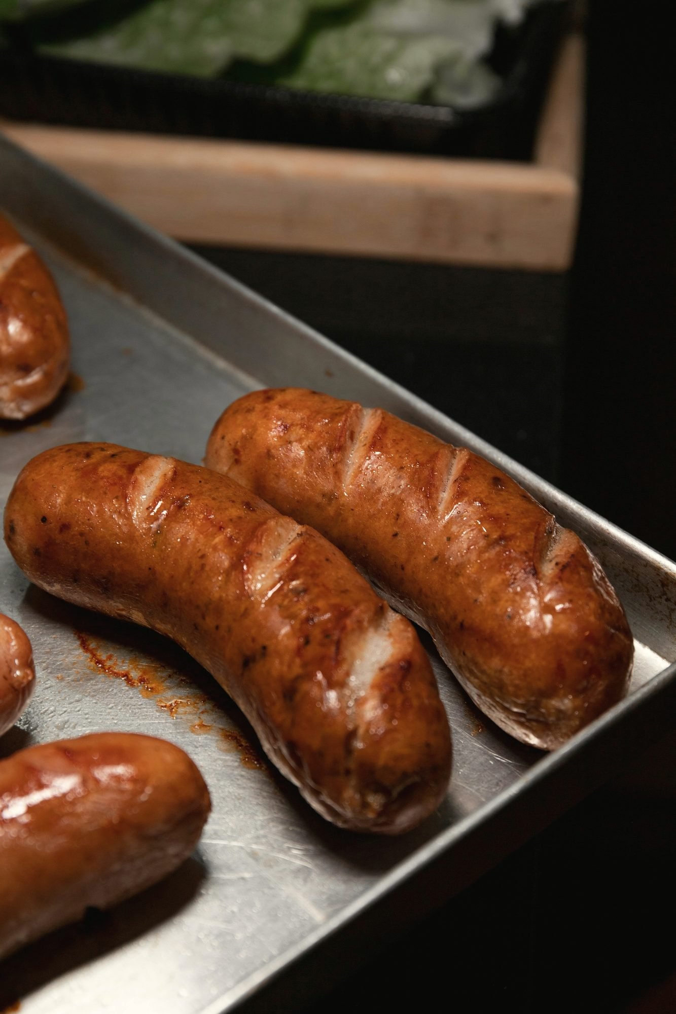 Browned pork sausages on a steel sheet pan